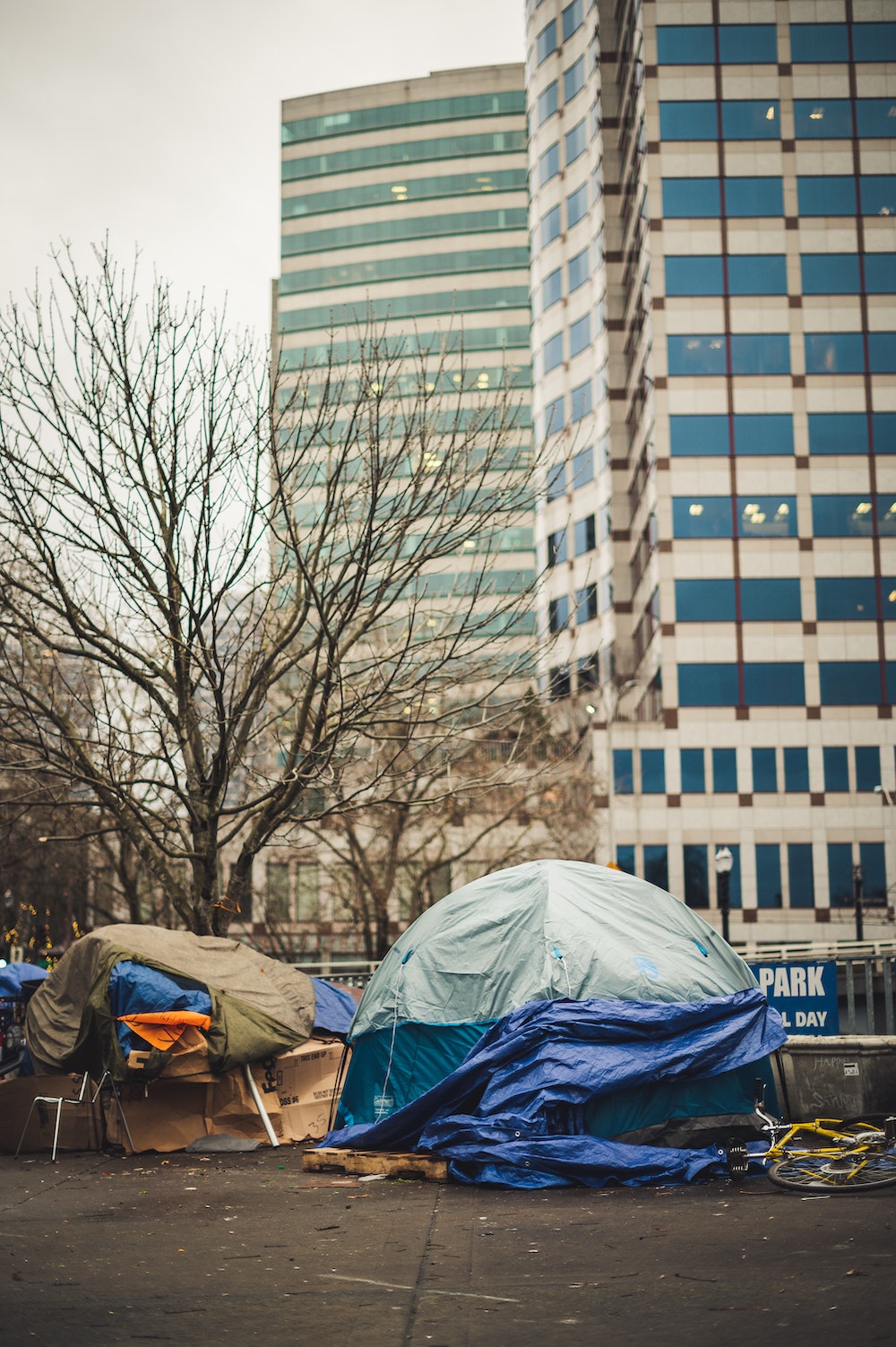 Photo of homeless camp below skyscraper